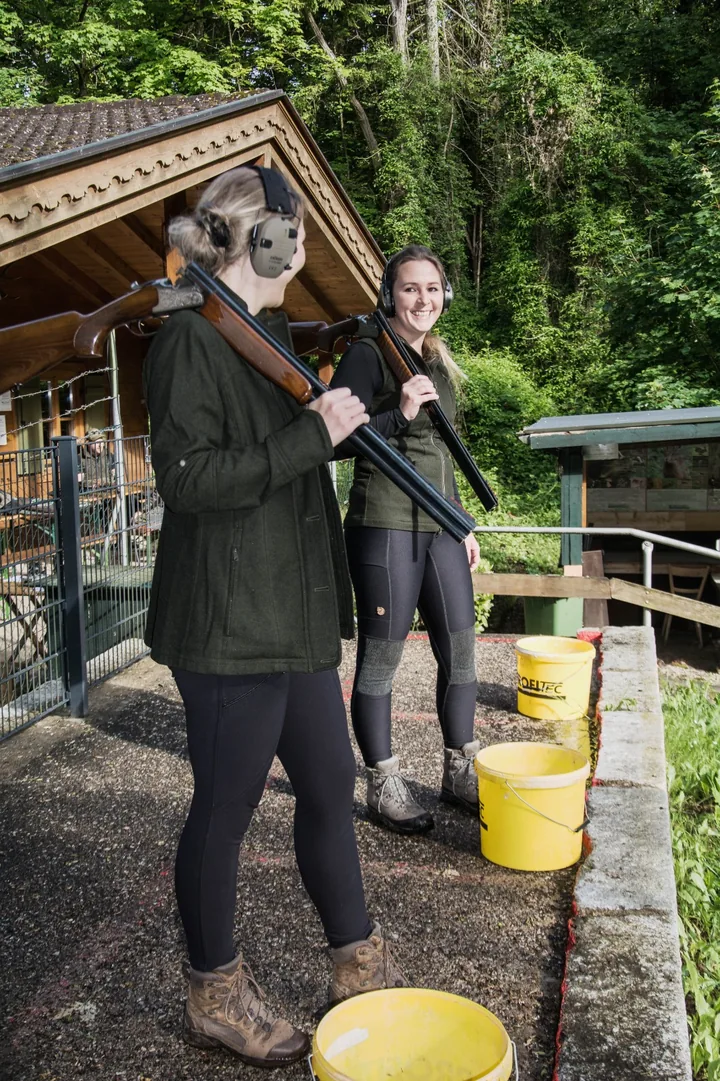 Two participants with shotguns and ear defenders at the Arzberg clay pigeon shooting ground